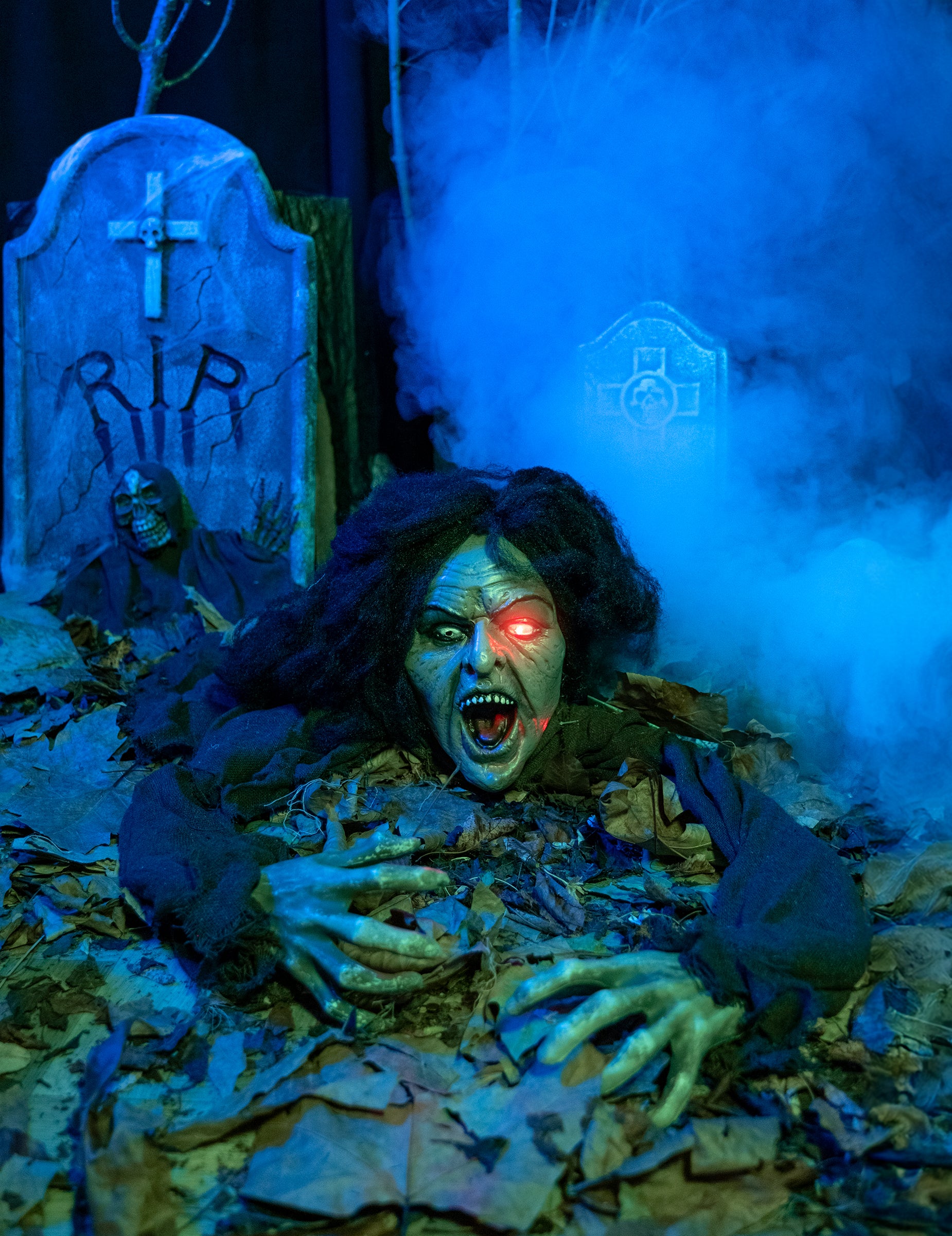 Mise en scène dans un cimetière de la décoration sorcière sonore et lumineuse pour Halloween