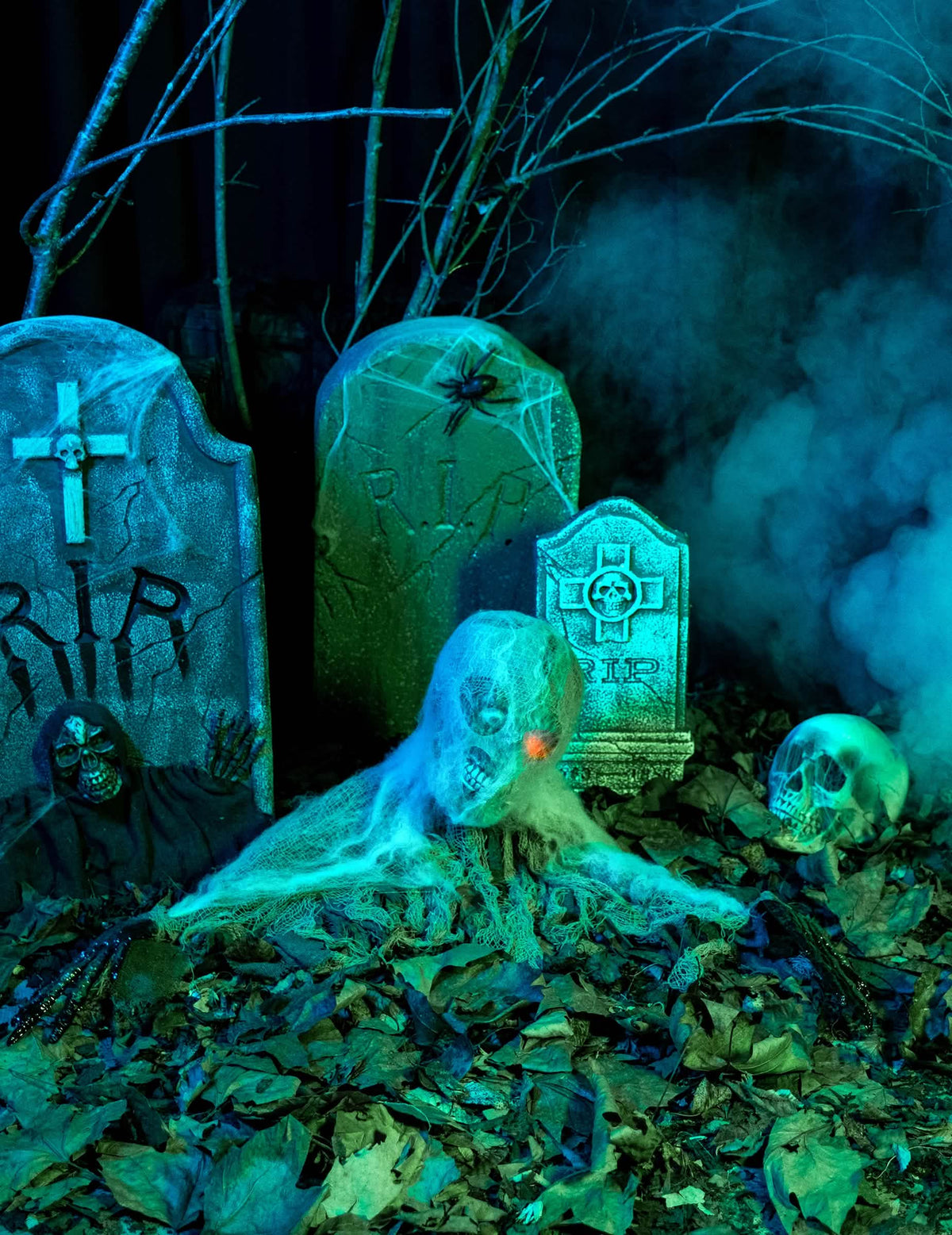 Prizor na pokopališču z animirano dekoracijo zombiji za halloween