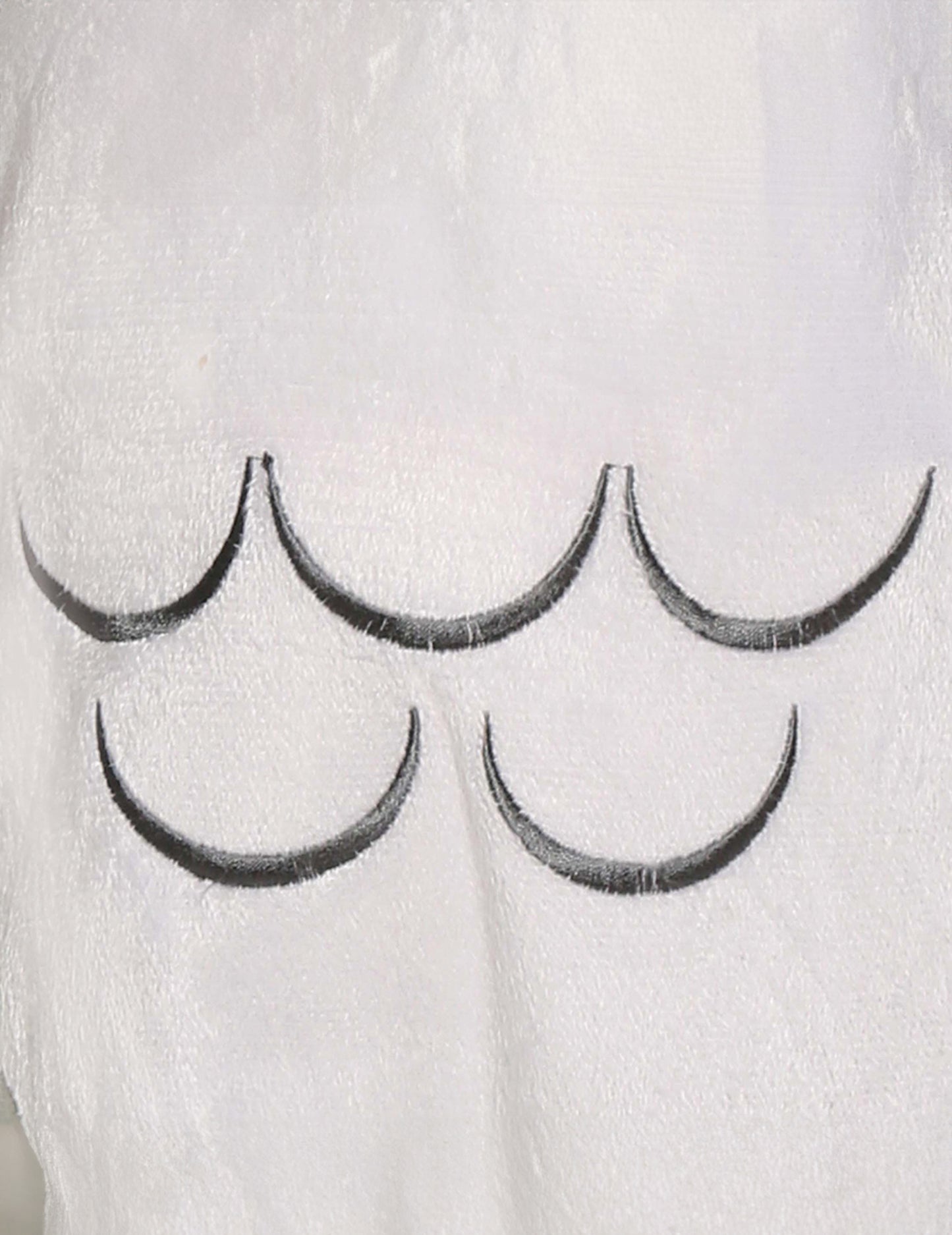 Gros plan sur les motifs de plumes du déguisement chouette magique pour bébé