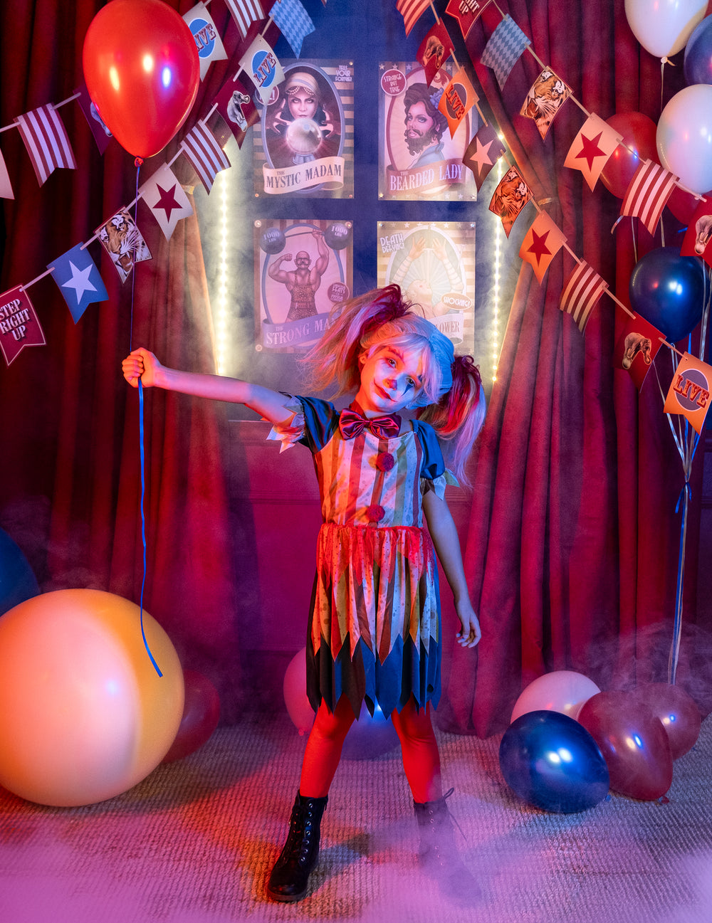Mise en scène dans un décor de cirque du déguisement clown tueur coloré Halloween pour fille