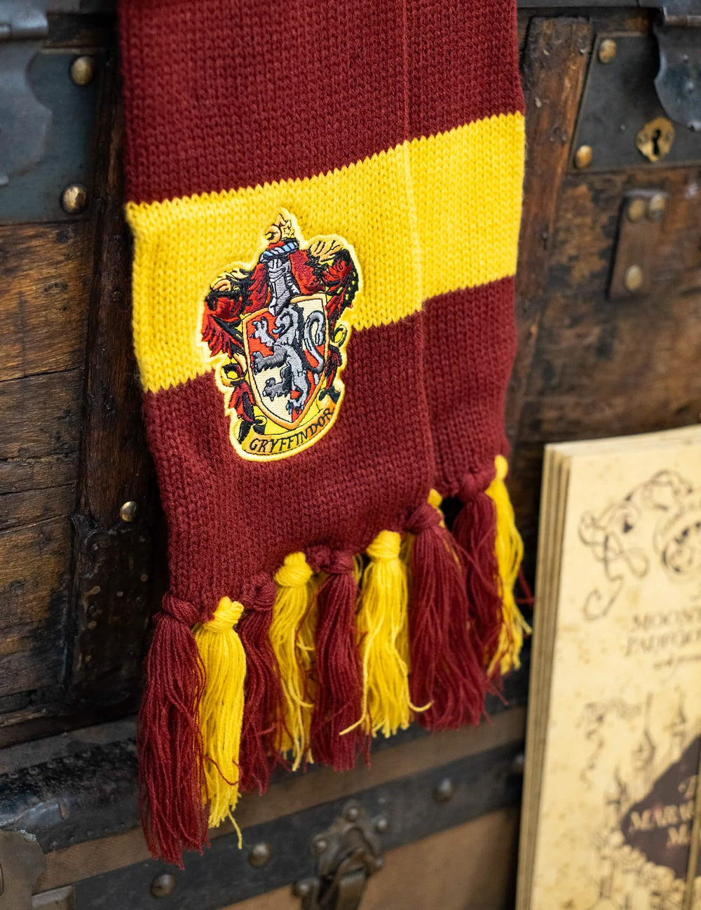 Bližnji posnetek vezenega grba na luksuznem šalu Gryffindor