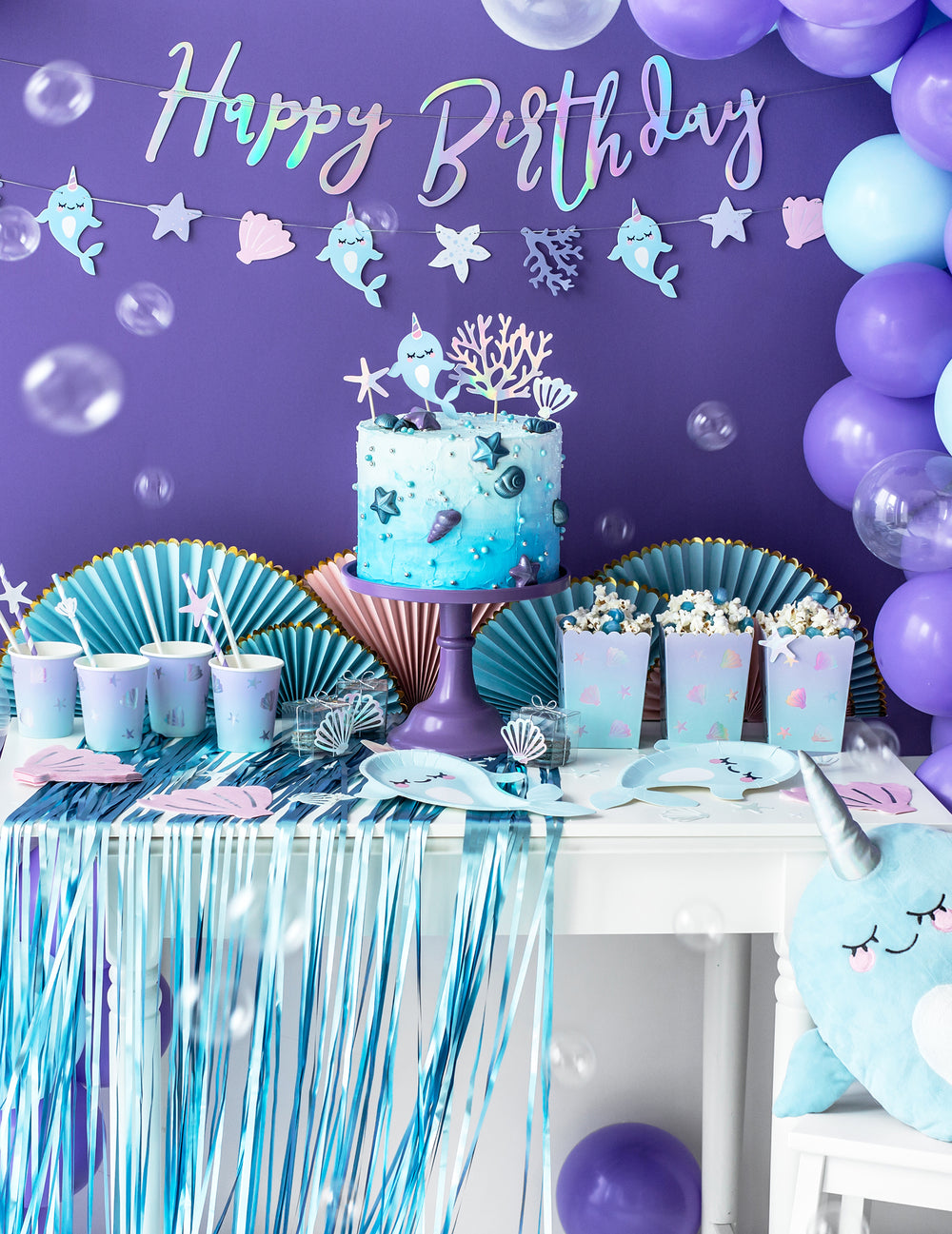 Table d'anniversaire décorée de la guirlande à monter soi-même licorne des mers
