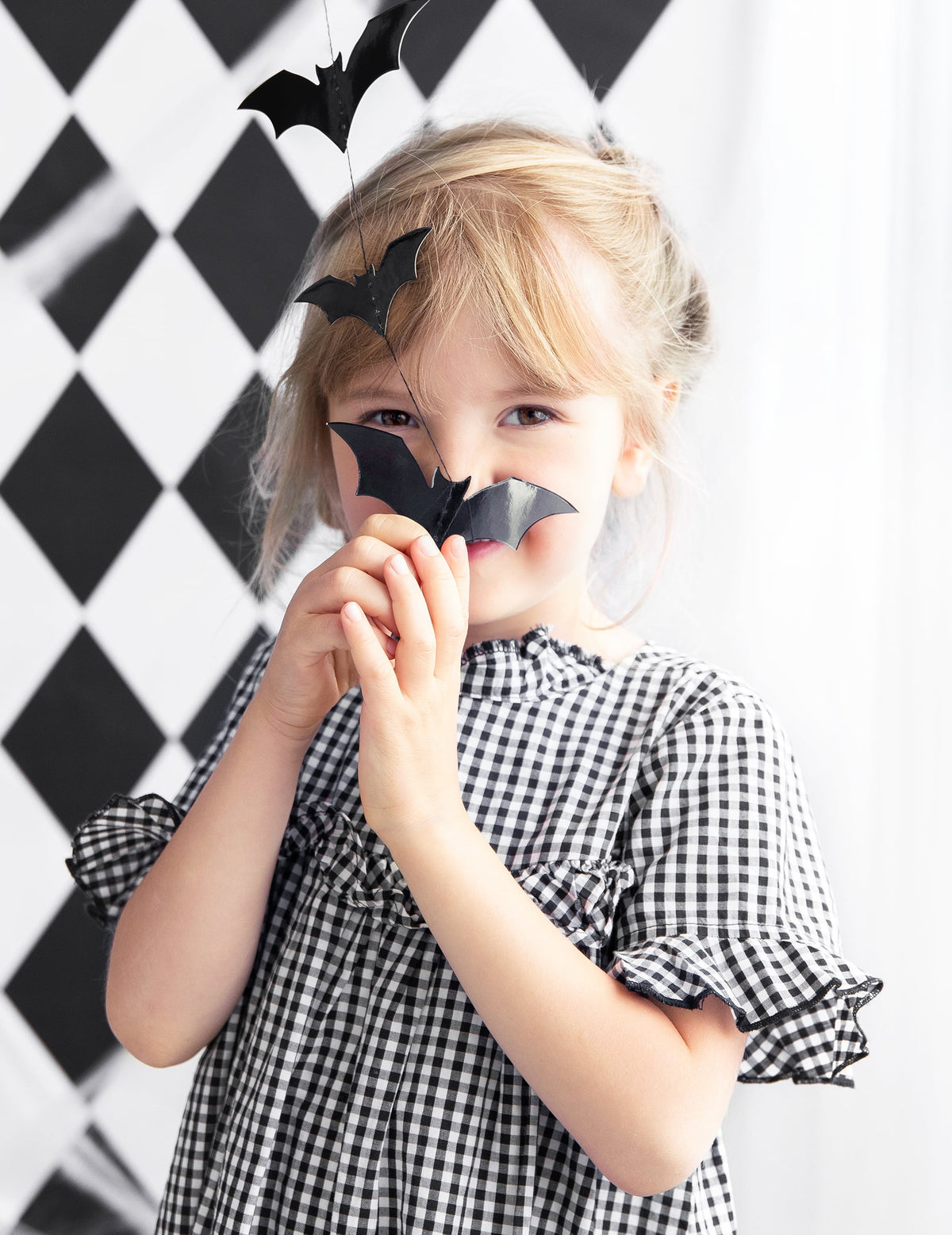 Mise en situation par un enfant de la guirlande chauve-souris pour décoration d'Halloween