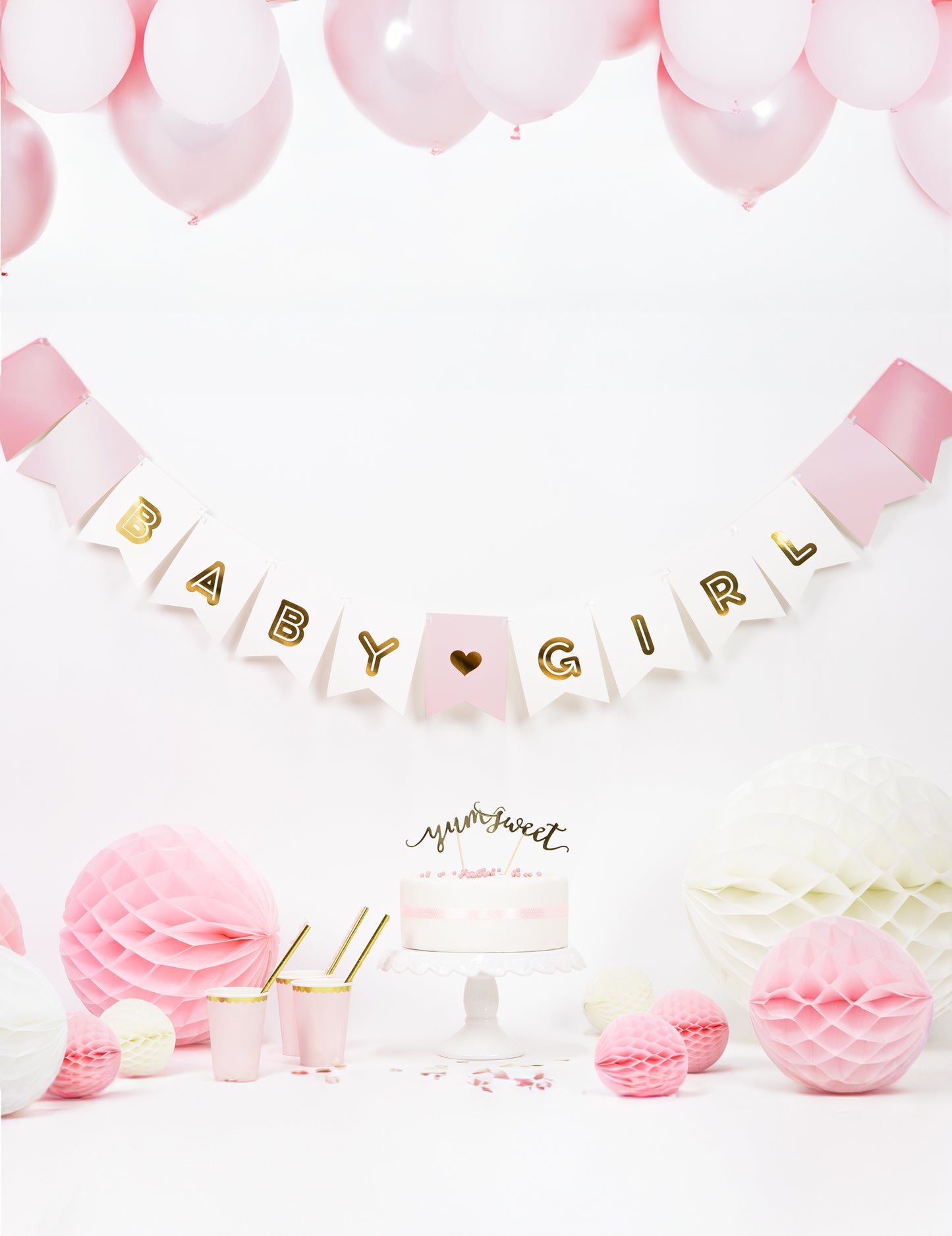 Mise en scène festive avec gâteau et ballons de la guirlande en carton baby girl pour baby shower
