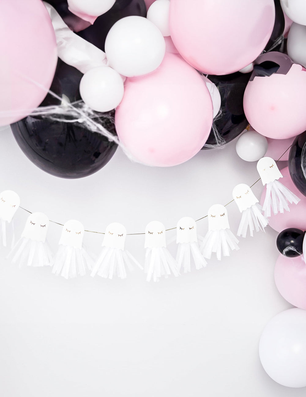 Mise en scène avec ballons de la guirlande en papier fantômes blanche et dorée à monter