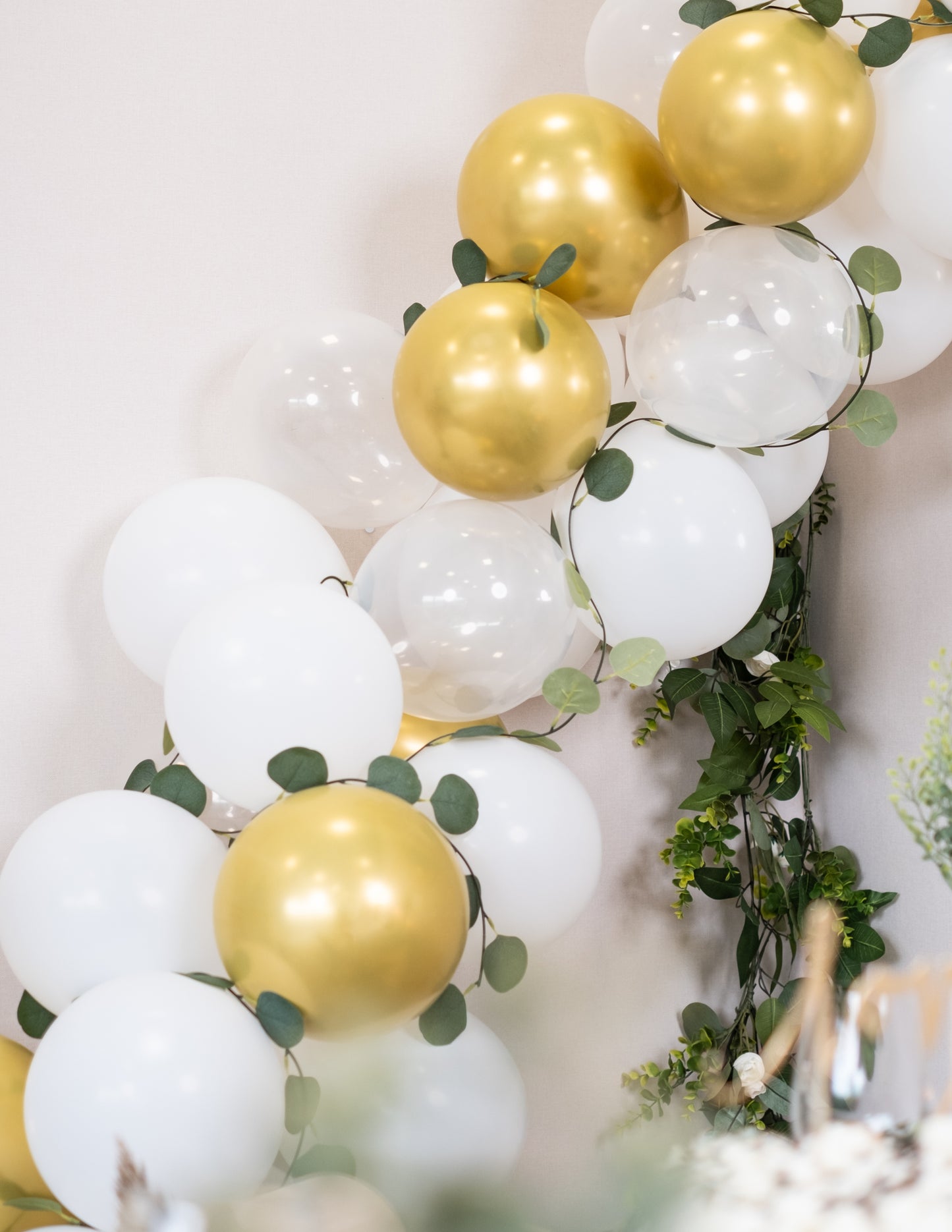 Komplet 60 balonov v obliki loka v beli in zlati barvi z listi evkaliptusa