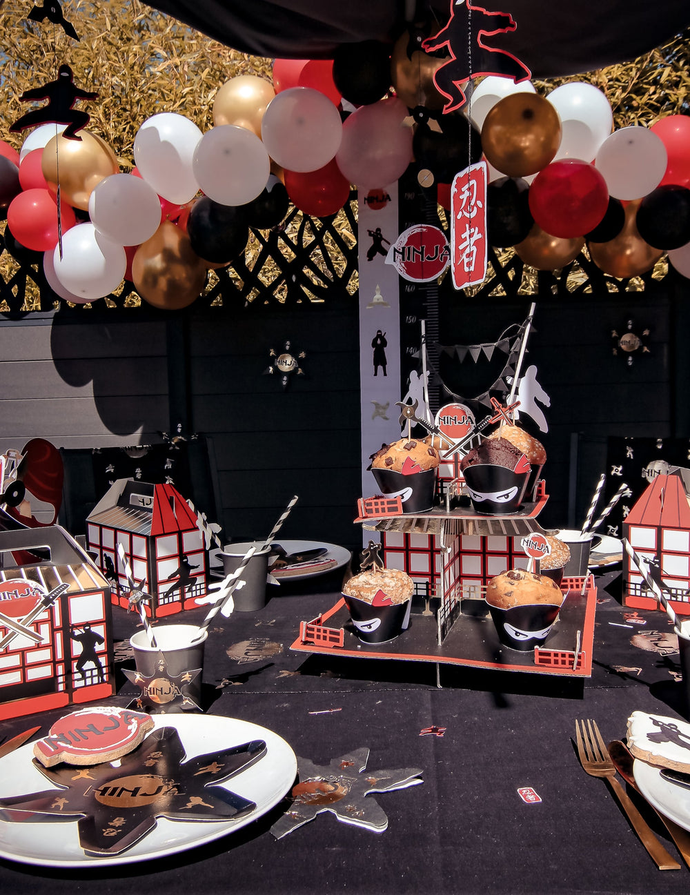 Mise en scène du kit arche de 60 ballons pour anniversaire dans un décor de fête ninja