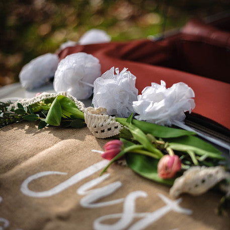 Détail des pompons blancs et fleurs du kit voiture des mariés champêtre Just Married