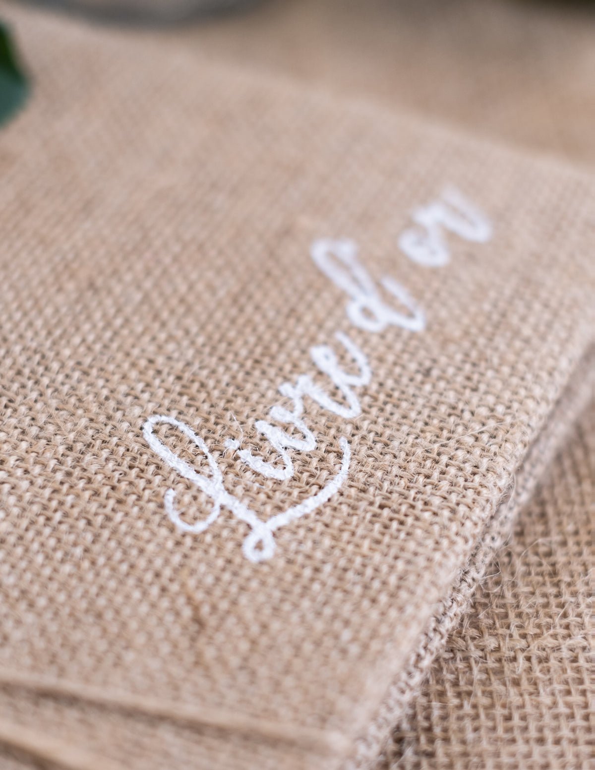 Gros plan sur l'inscription blanche du livre d'or mariage nature