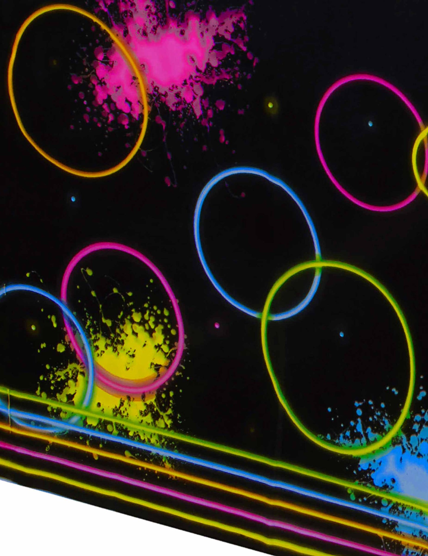 Gros plan sur les motifs cercles et taches néon de la nappe en plastique Glow Party noire