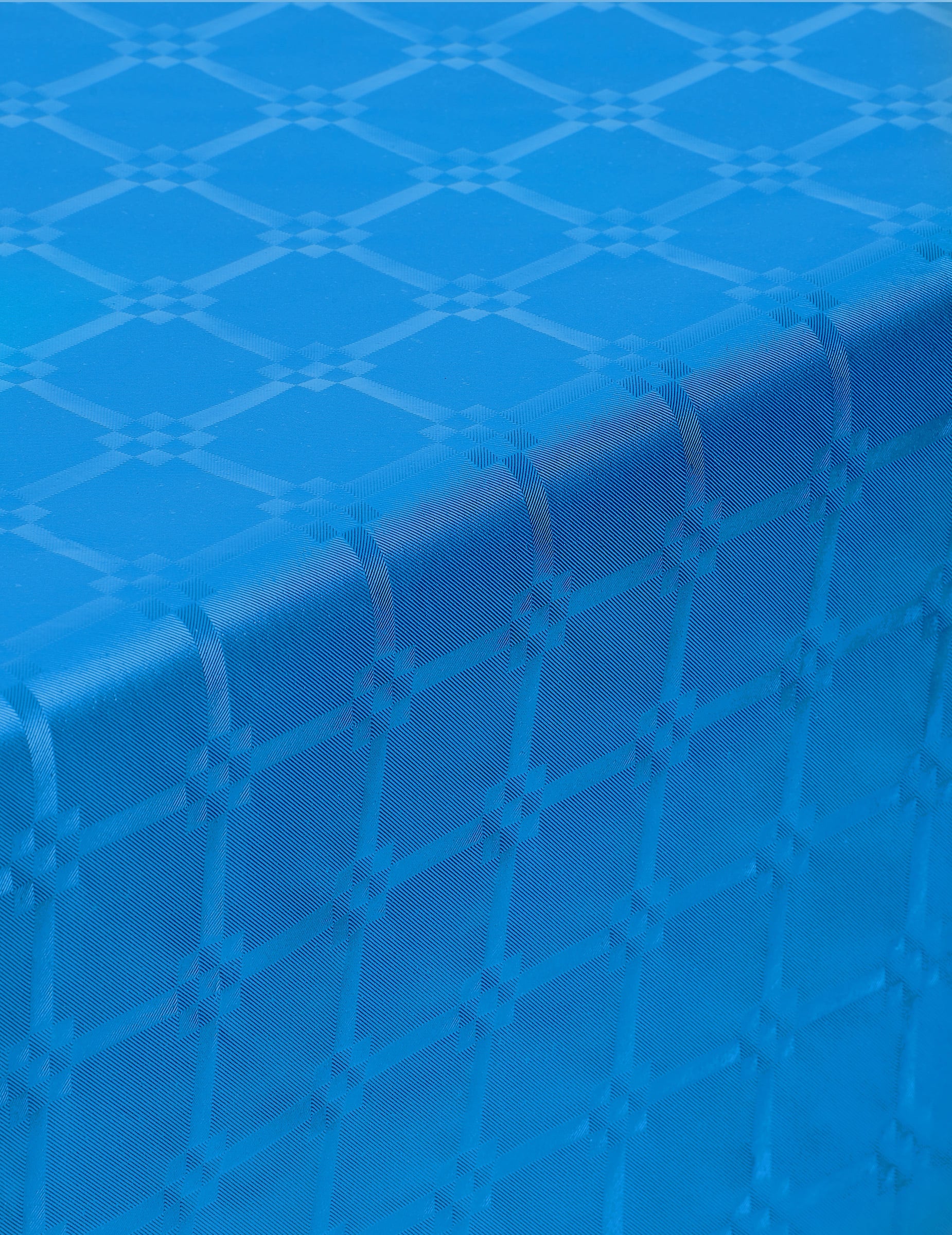 Gros plan sur le relief de la nappe en rouleau papier damassé bleu avec motifs de frises grecques