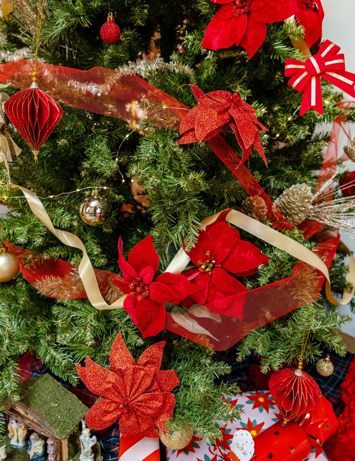 Mise en situation sur un sapin de Noël du nœud de poinsettia avec grelots pour décoration de table