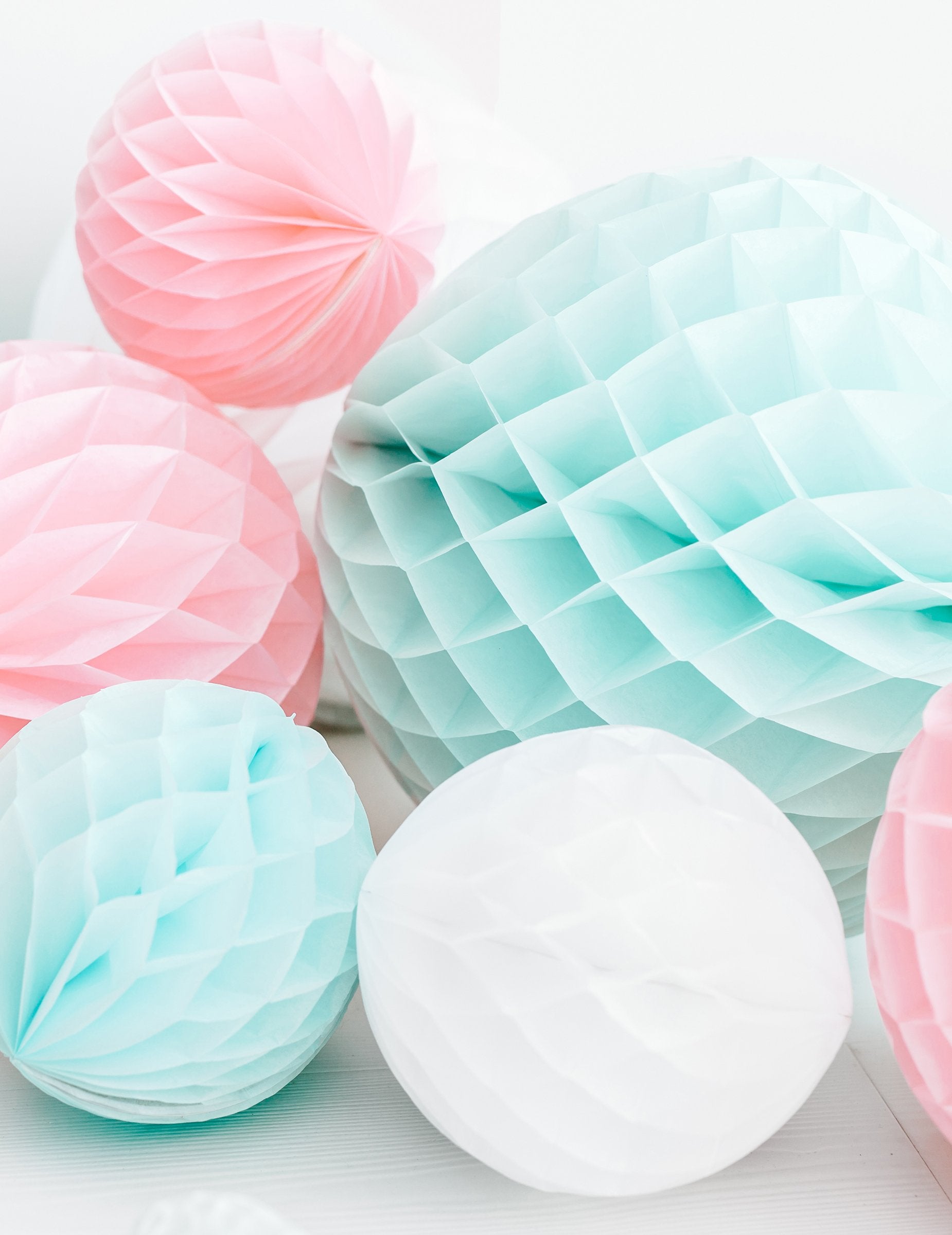 Gros plan sur les différents coloris de la boule en papier alvéolé pour déco de fête