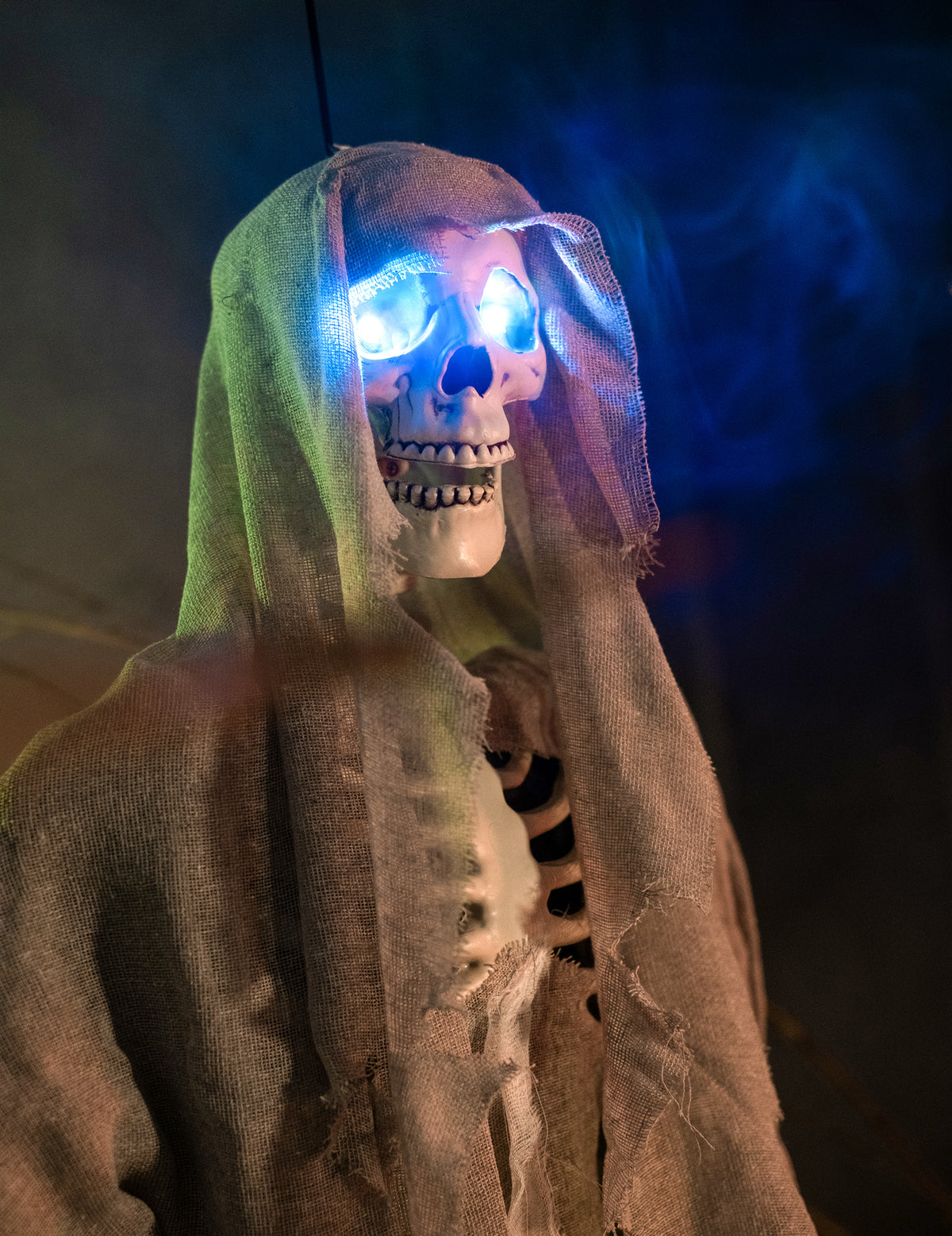 Gros plan sur les yeux bleus lumineux du squelette lumineux à suspendre Halloween