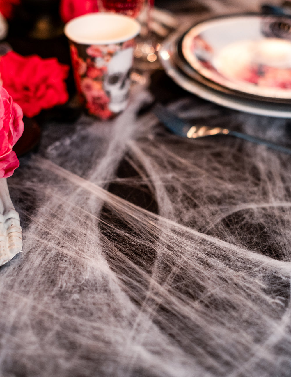 Détail de la mise en scène sur table de la toile d'araignée Halloween blanche